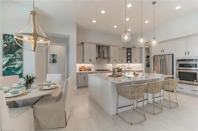 a kitchen with kitchen island stainless steel appliances a sink and a refrigerator