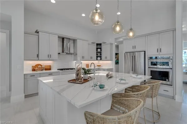 a kitchen with stainless steel appliances granite countertop a sink refrigerator and cabinets