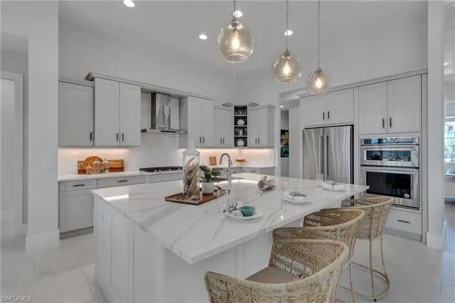 a kitchen with stainless steel appliances granite countertop a sink refrigerator and cabinets