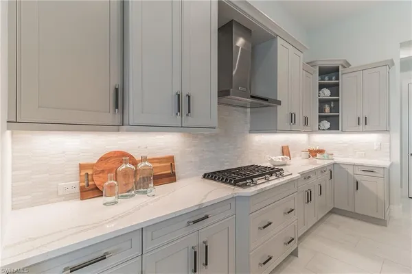 a kitchen with white cabinets and appliances