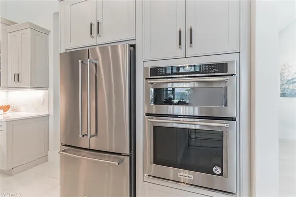 a kitchen with granite countertop white cabinets and stainless steel appliances