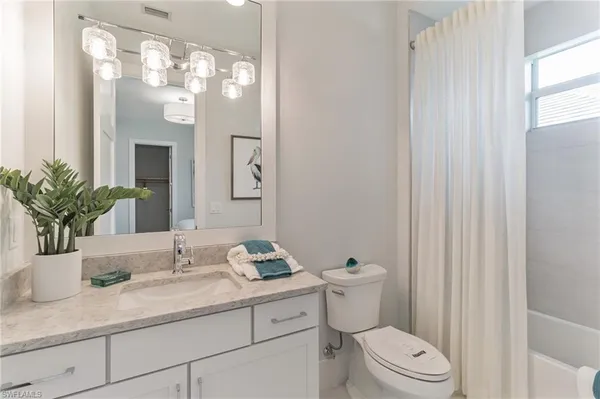 a bathroom with a granite countertop sink a toilet and a mirror