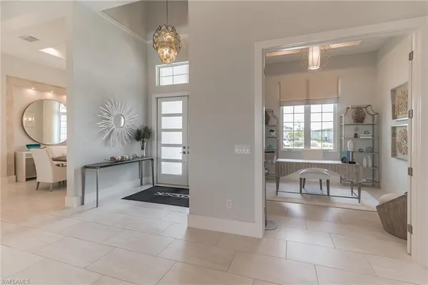 a living room with furniture and a large mirror next to a window