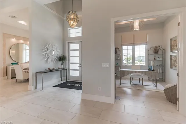 a living room with furniture and a large mirror next to a window