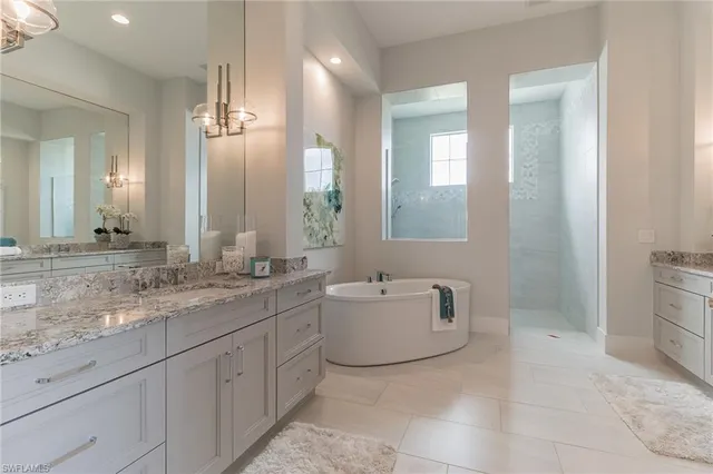 a bathroom with a granite countertop sink mirror and bathtub