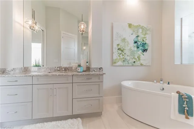 a bathroom with a double vanity sink mirror and bathtub