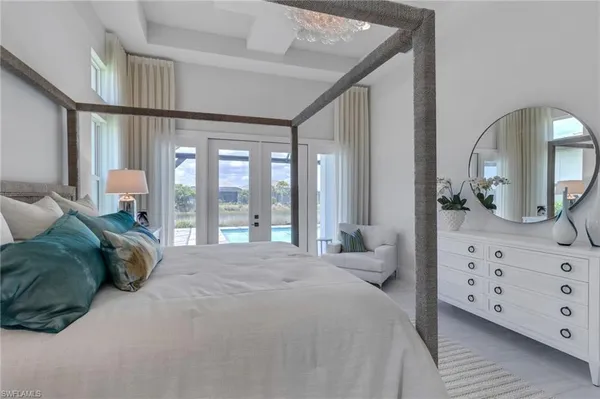 a spacious bedroom with a bed a window and dresser