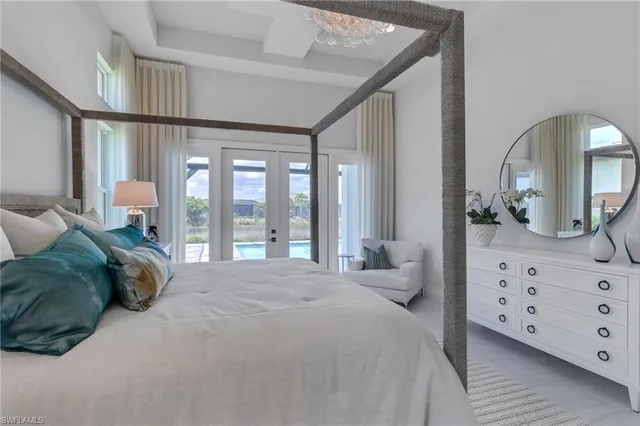 a spacious bedroom with a bed a window and dresser