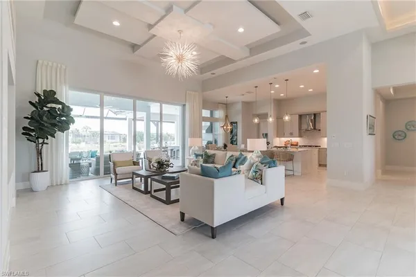 a living room with furniture and a large window with kitchen view