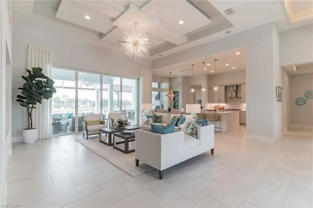 a living room with furniture and a large window with kitchen view