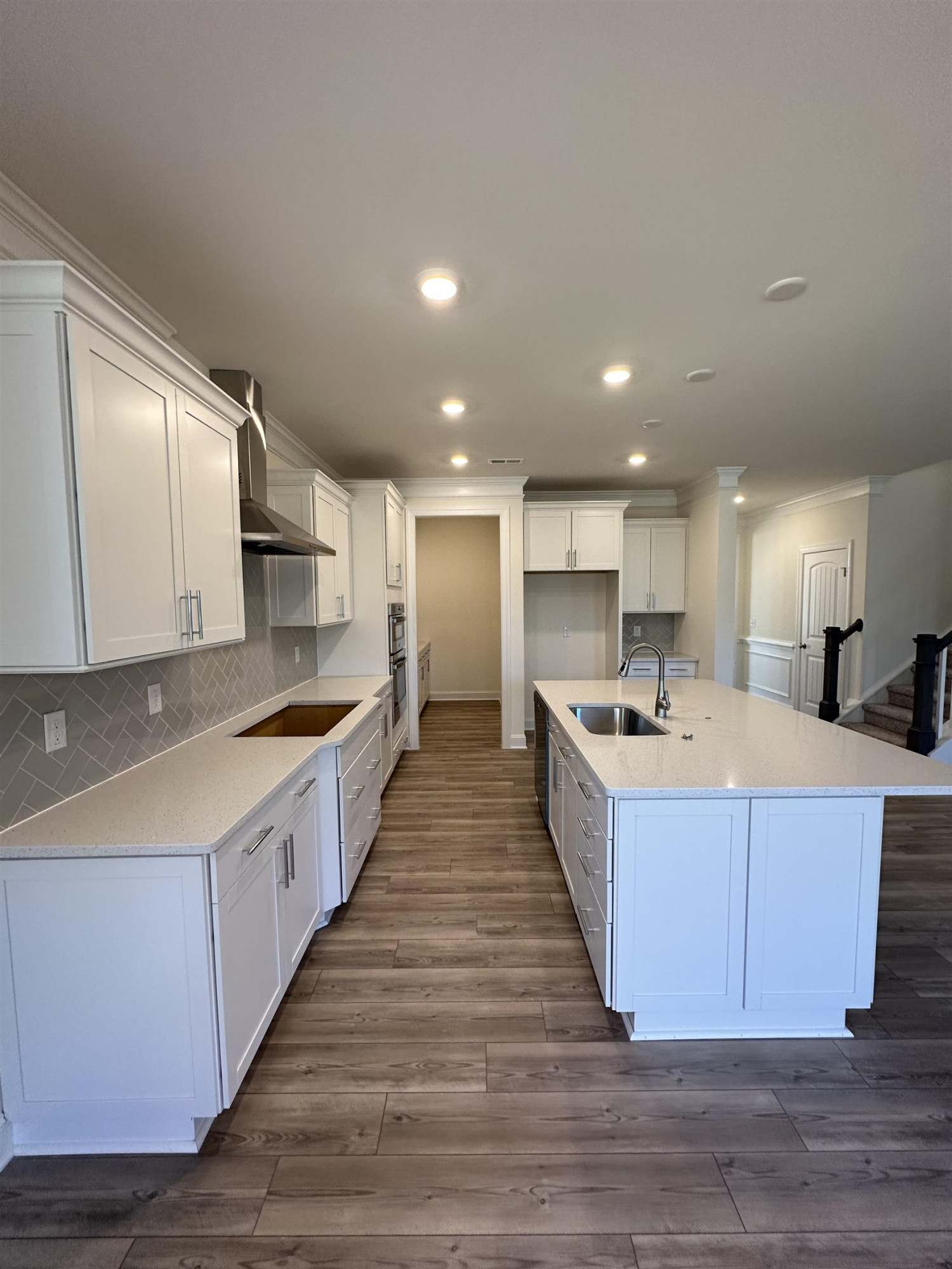 4304 Beckel Road Willow Spring, NC 27592 - Photo 6 of 28 a large white kitchen with kitchen island a sink wooden floor and a counter top space