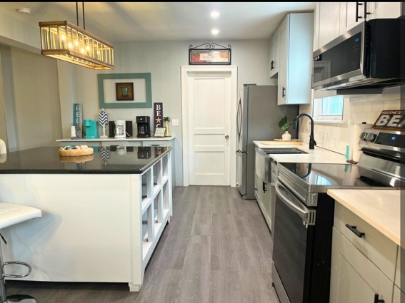 2524 Stinson Road Nashville, TN 37214 - Photo 3 of 23 a kitchen with stainless steel appliances a stove top oven a sink dishwasher a refrigerator white cabinets and wooden floor