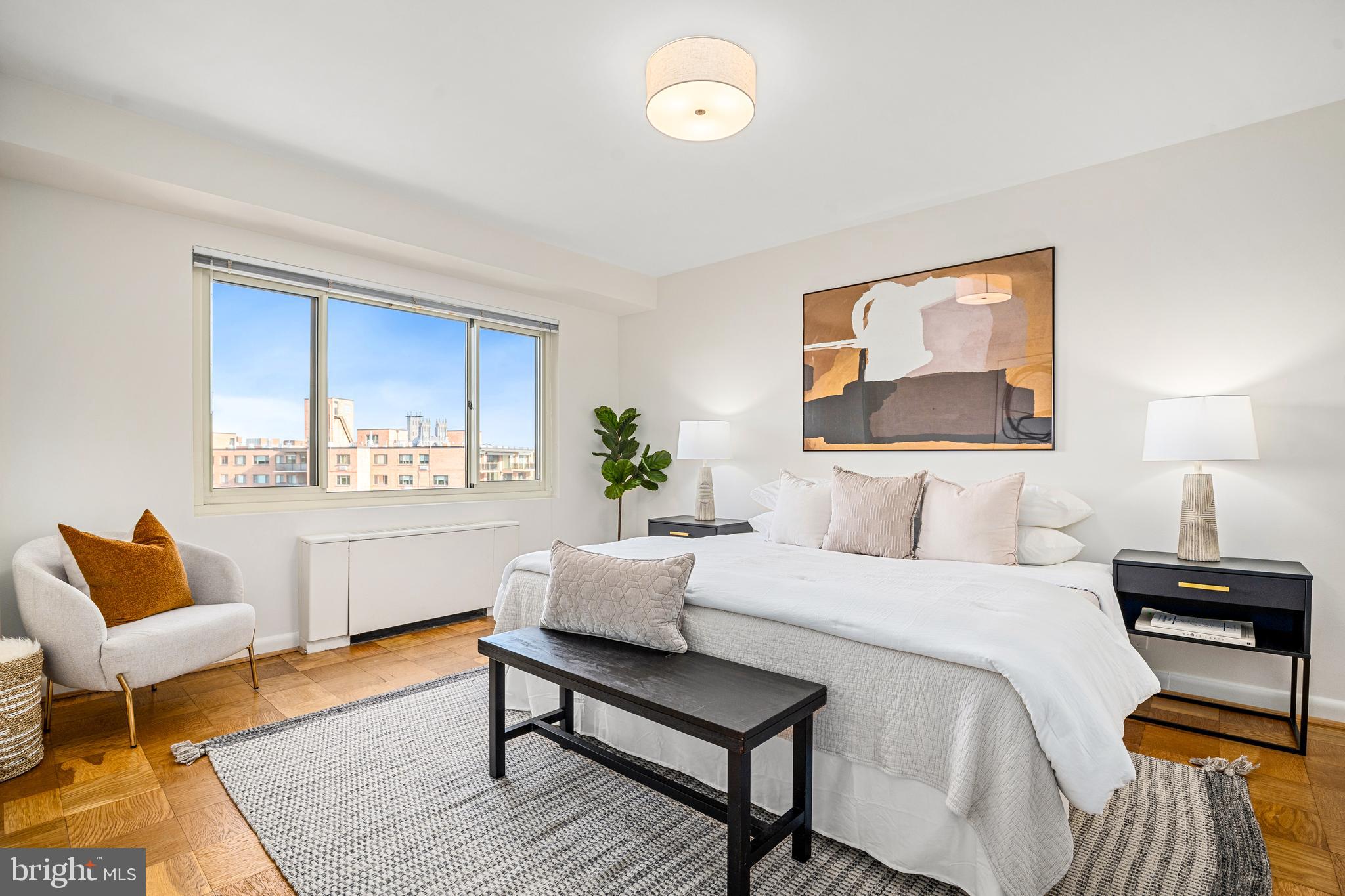 4201 Cathedral Avenue Northwest, Unit 1415W Washington, DC 20016 - Photo 21 of 36 a bedroom with a bed and wooden floor