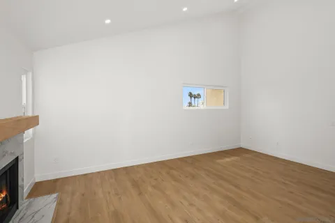 an empty room with wooden floor and a fireplace