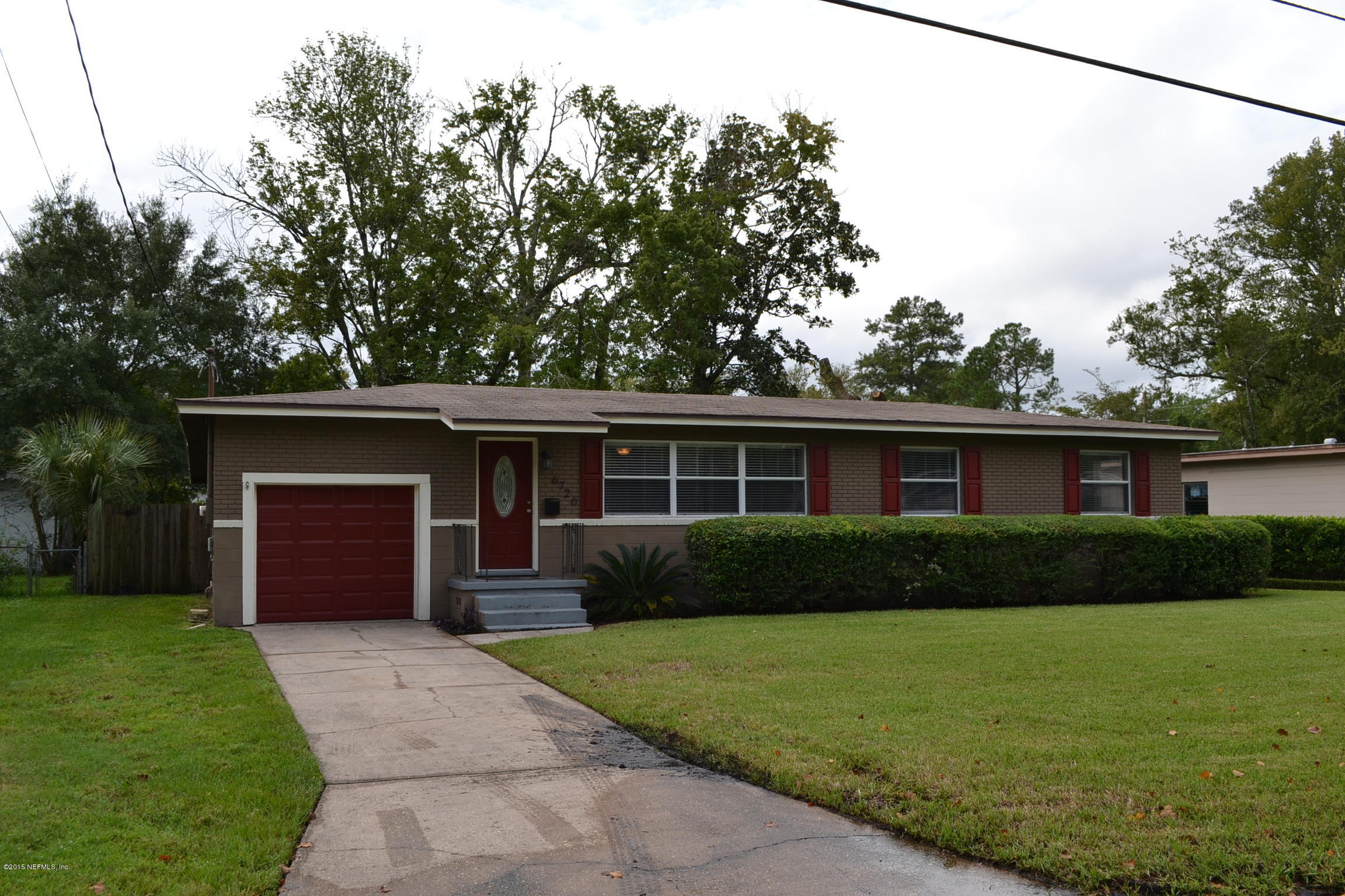 6720 E Road Jacksonville, FL 32216 - Photo 1 of 16 a front view of a house with a yard and a garage