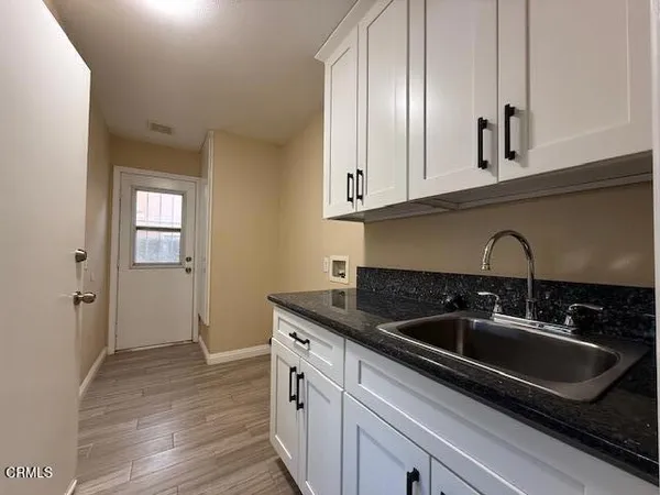 a kitchen with granite countertop a sink and cabinets