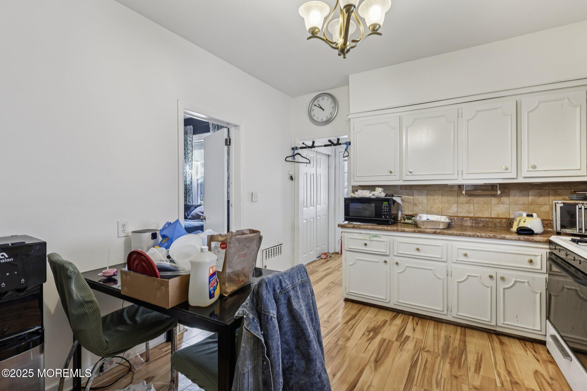 16 Reimer Street Raritan, NJ 08869 - Photo 7 of 30 a kitchen with stainless steel appliances kitchen island granite countertop a table chairs in it and white cabinets