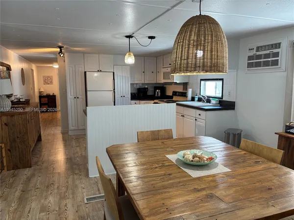 a kitchen with stainless steel appliances granite countertop a stove a refrigerator a oven a sink with a dining table and chairs