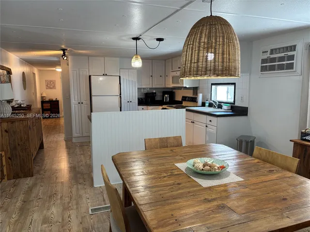 a kitchen with stainless steel appliances granite countertop a stove a refrigerator a oven a sink with a dining table and chairs