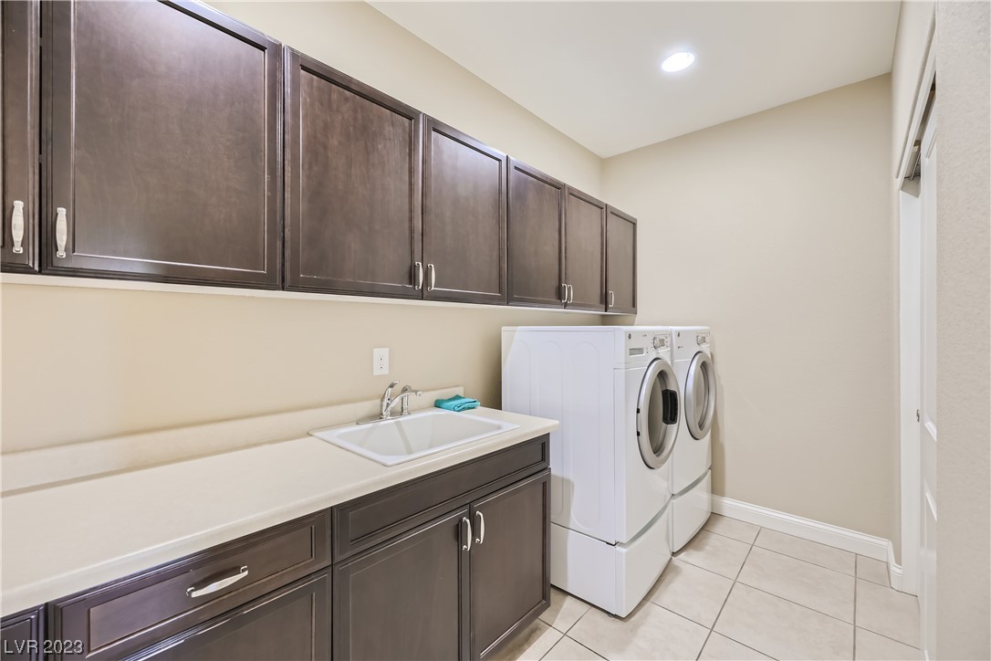 7421 Manse Ranch Avenue Las Vegas, NV 89179 - Photo 34 of 50 The laundry room has extended cabinets and a laund