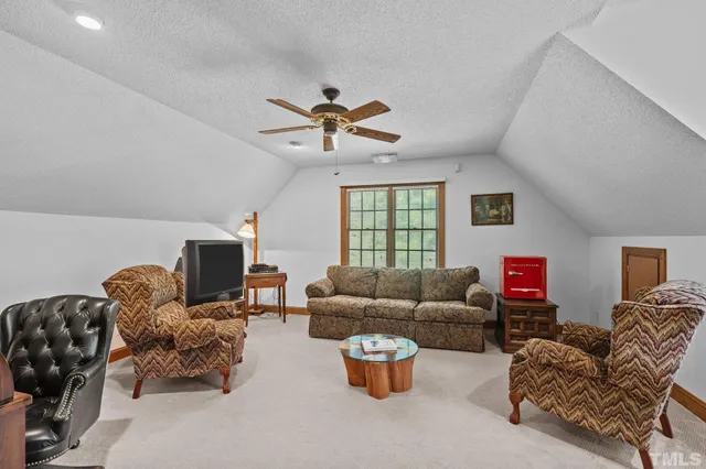 a living room with furniture a flat screen tv and a window