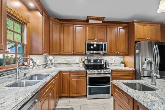 a kitchen with stainless steel appliances granite countertop a sink stove and refrigerator