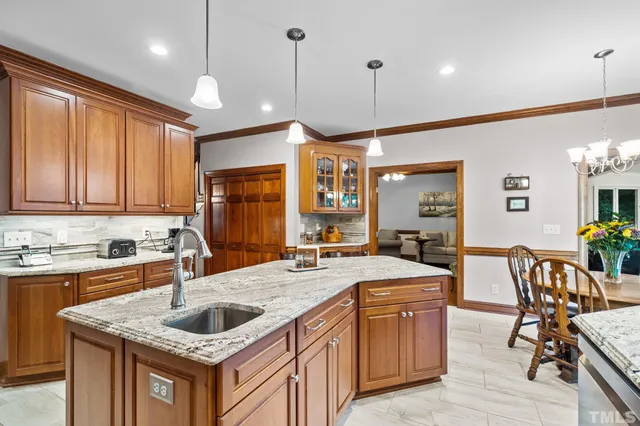a kitchen with stainless steel appliances granite countertop a sink a stove and a wooden floors