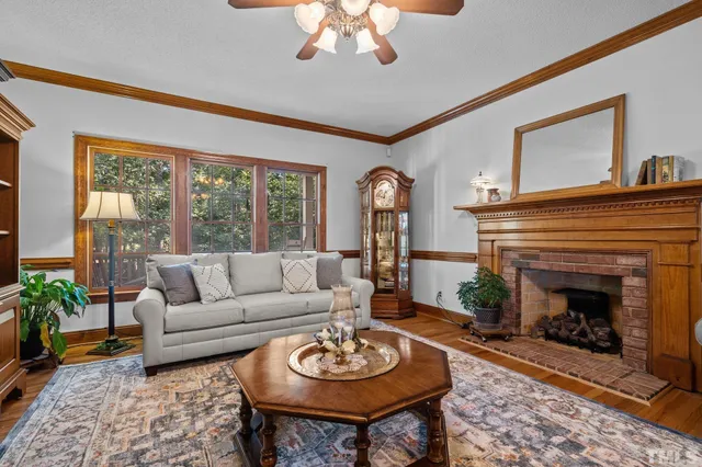 a living room with furniture a fireplace and a large window