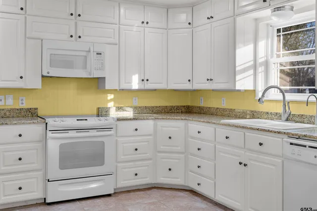 a large white kitchen with cabinets
