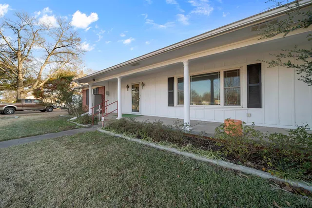 a view of an empty room with wooden floor and windows