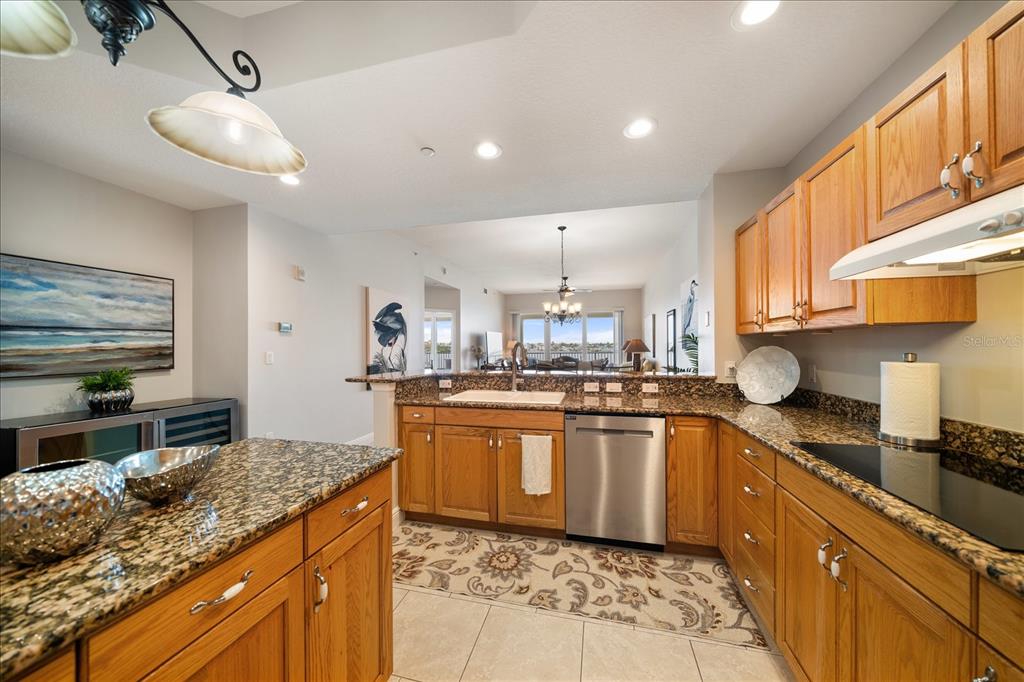17735 Gulf Boulevard, Unit 304 Redington Shores, FL 33708 - Photo 19 of 66 a kitchen with stainless steel appliances granite countertop a sink a stove and a wooden cabinets
