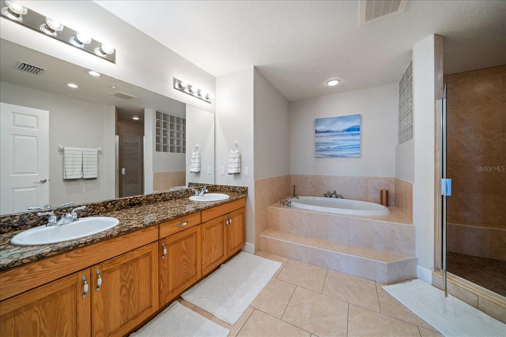 17735 Gulf Boulevard, Unit 304 Redington Shores, FL 33708 - Photo 34 of 66 a spacious bathroom with a granite countertop double vanity sink a mirror and a bathtub