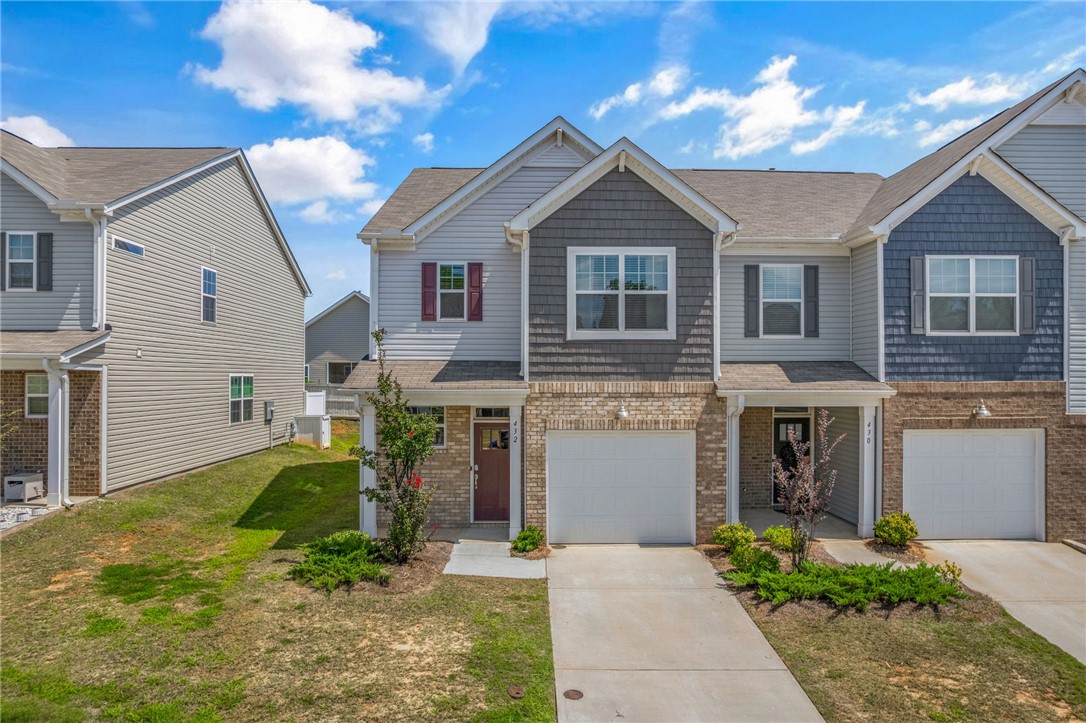 432 Bee Cv Way Pendleton, SC 29670 - Photo 4 of 39 This charming townhome presents a welcoming facade with a mix of brick and siding, featuring a neatly maintained lawn.