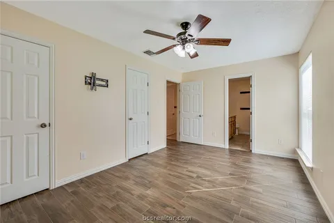 wooden floor in an empty room with a fan