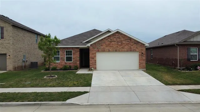 a front view of a house with a yard and a garage