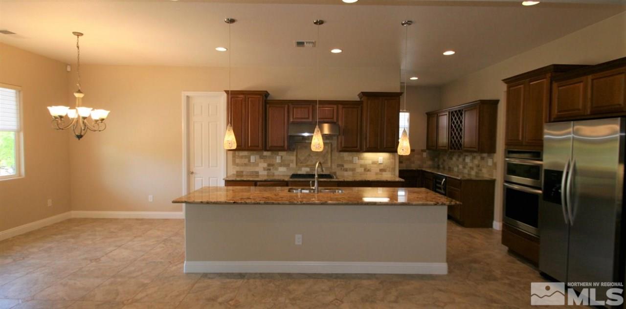 2098 Blue Boy Lane Reno, NV 89521 - Photo 5 of 26 a kitchen with kitchen island granite countertop cabinets and refrigerator