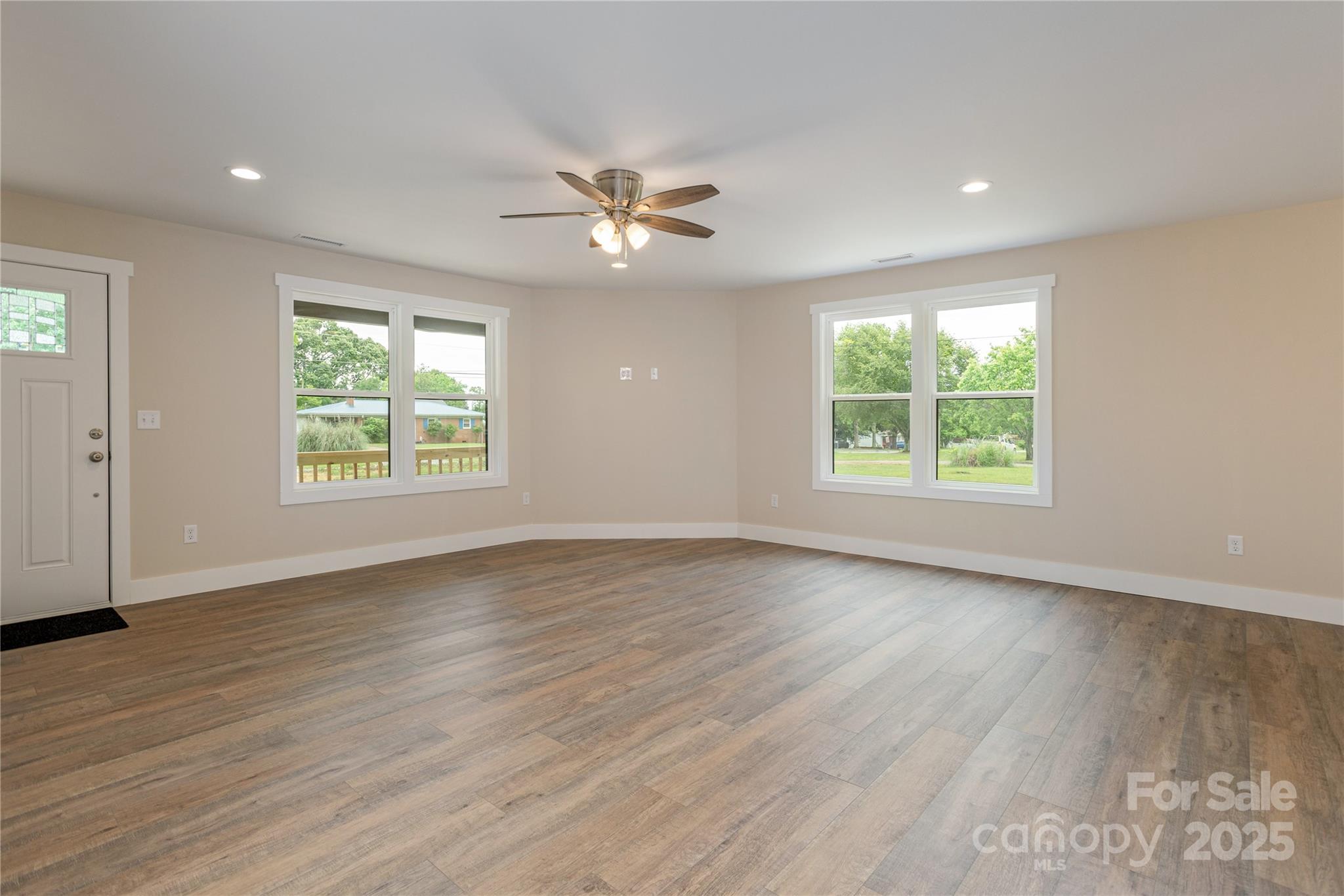 782 Poors Ford Road Rutherfordton, NC 28139 - Photo 5 of 25 an empty room with wooden floor chandelier fan and windows