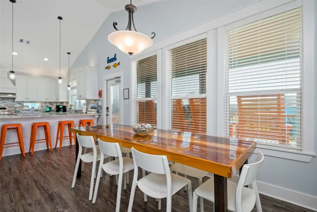 a kitchen with stainless steel appliances granite countertop a refrigerator a sink dishwasher a stove and white cabinets with wooden floor