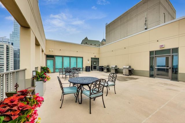 a view of a patio with a table and chairs and potted plants