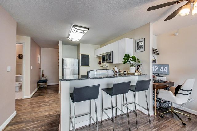 a kitchen with a dining table chairs cabinets and stainless steel appliances