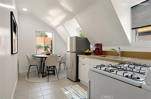 a kitchen with a stove a refrigerator and a dining table