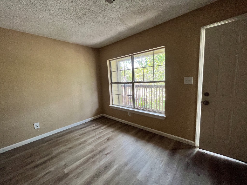10235 Algiers Road, Unit 2 Houston, TX 77041 - Photo 2 of 12 a view of an empty room with wooden floor and a window