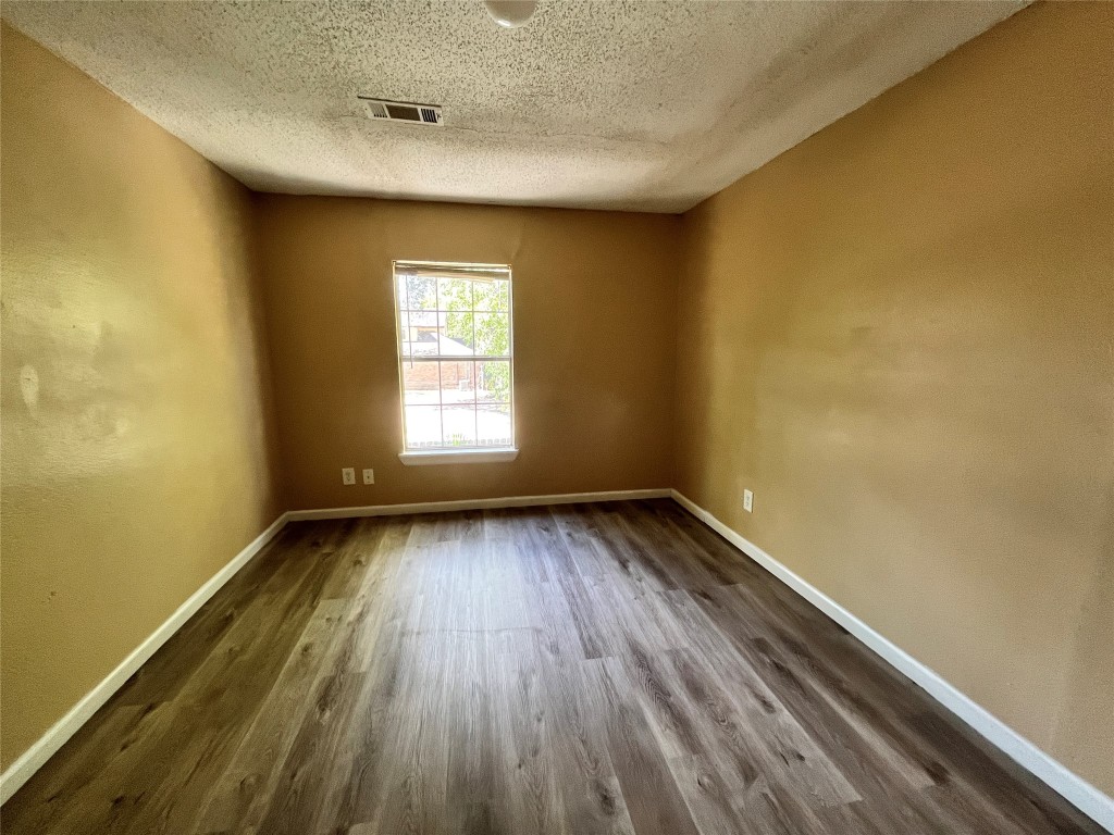 10235 Algiers Road, Unit 2 Houston, TX 77041 - Photo 6 of 12 an empty room with wooden floor and windows