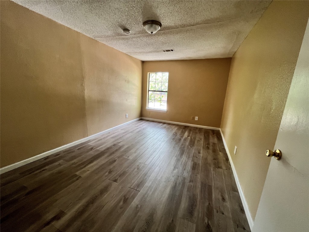 10235 Algiers Road, Unit 2 Houston, TX 77041 - Photo 9 of 12 wooden floor in an empty room with a window