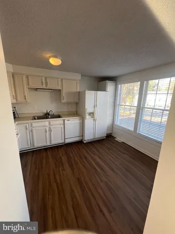 a view of a livingroom with wooden floor and staircase