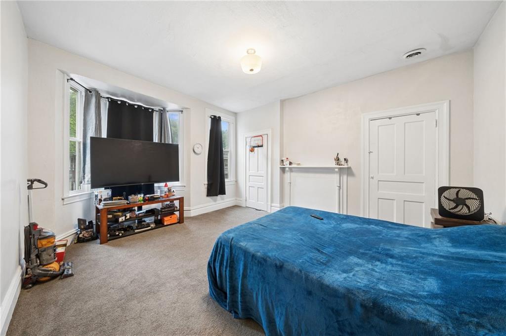 1523 Evergreen Road Pittsburgh, PA 15209 - Photo 24 of 35 a bedroom with a bed and a flat screen tv