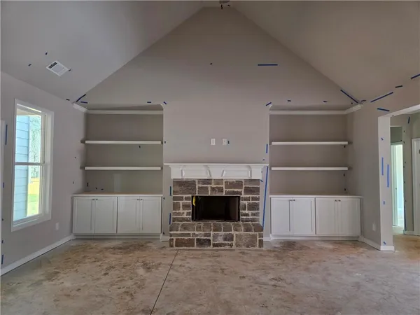 a view of an empty room with a fireplace and a window