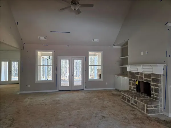 an empty room with windows and fireplace