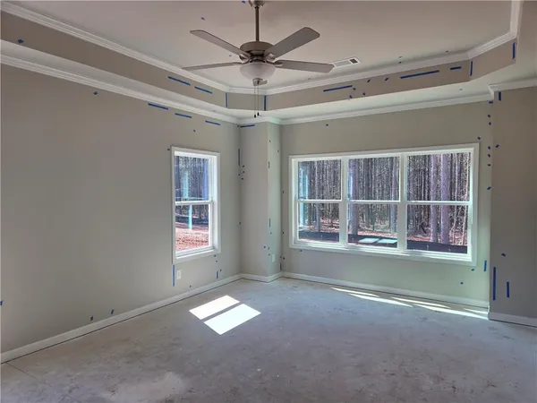 en empty room with windows and ceiling fan