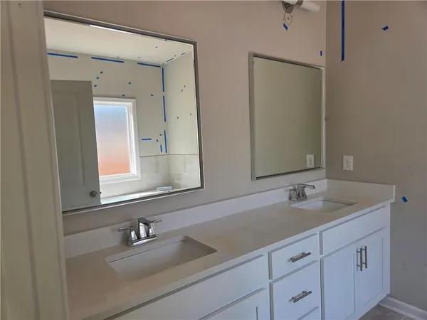 a bathroom with double sink and a mirror